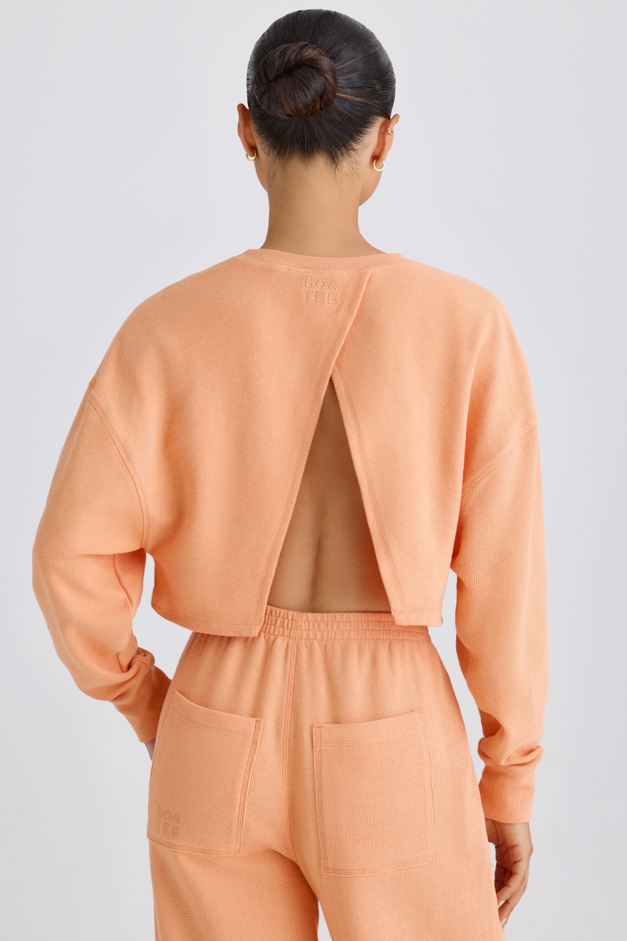 Jet Set Crew-Neck Open-Back Cropped Sweatshirt in Peach - Image 7