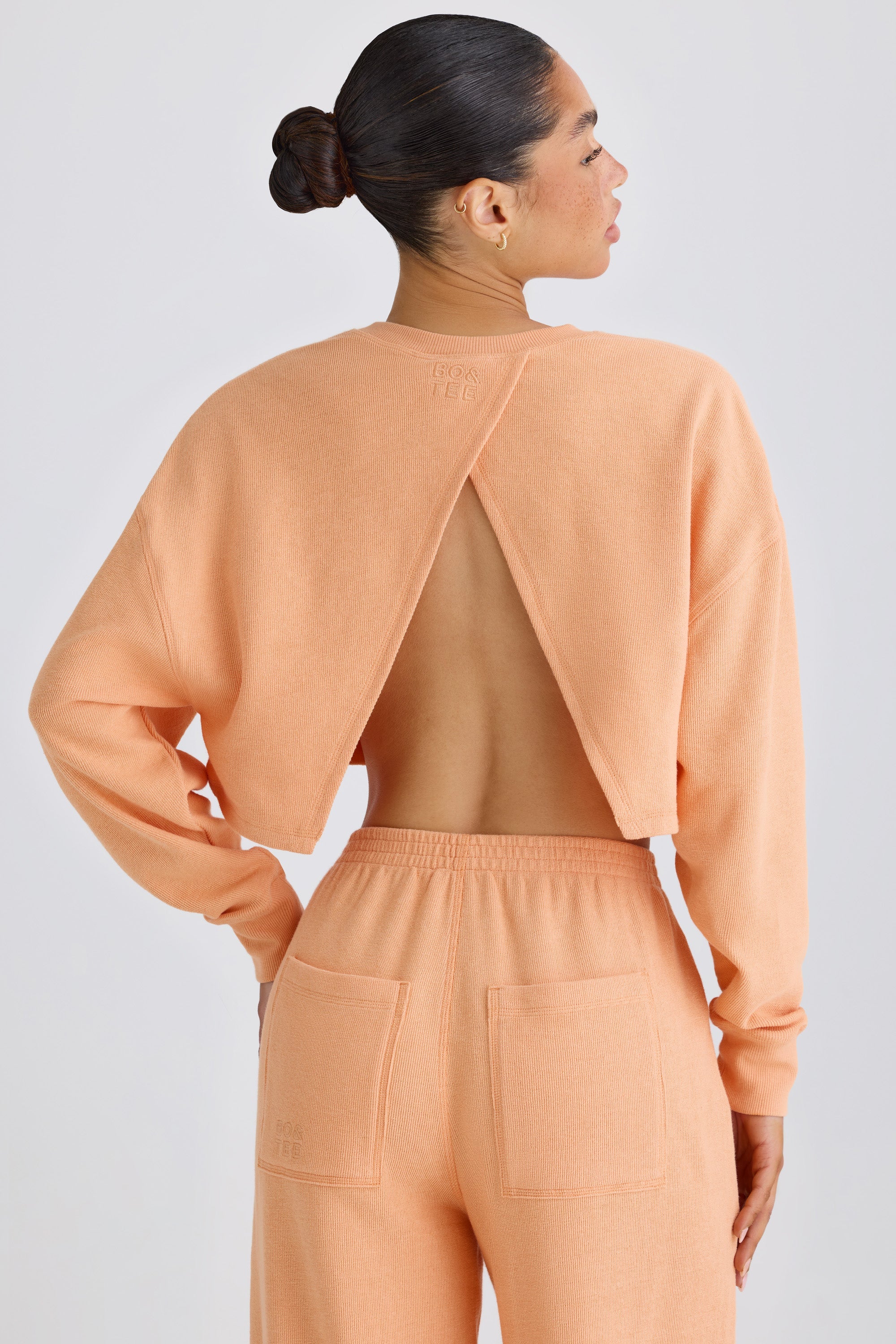 Jet Set Crew-Neck Open-Back Cropped Sweatshirt in Peach